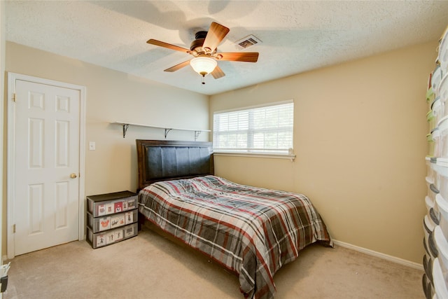 carpeted bedroom with a textured ceiling and ceiling fan