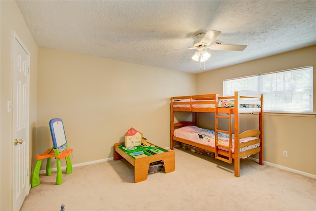 bedroom with a textured ceiling, ceiling fan, and carpet flooring