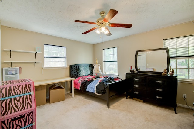 carpeted bedroom with multiple windows, a textured ceiling, and ceiling fan