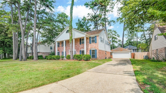 neoclassical / greek revival house with a garage, an outbuilding, and a front lawn