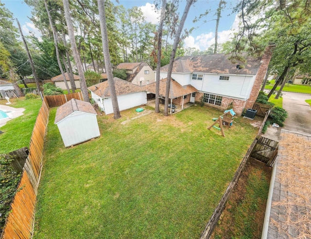 view of yard with central AC and a storage unit