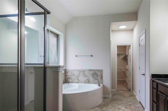 bathroom featuring tile patterned flooring, vanity, lofted ceiling, and independent shower and bath