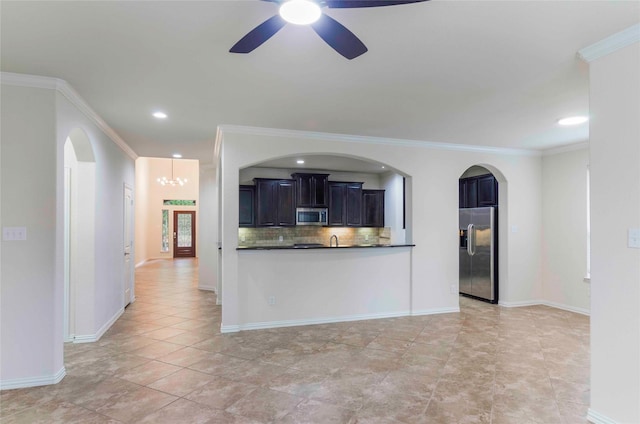 kitchen with tasteful backsplash, stainless steel appliances, ceiling fan with notable chandelier, and ornamental molding