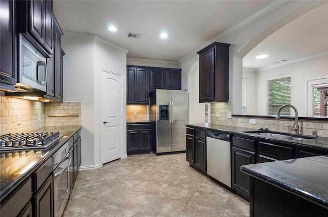 kitchen with stainless steel appliances, tasteful backsplash, ornamental molding, and sink