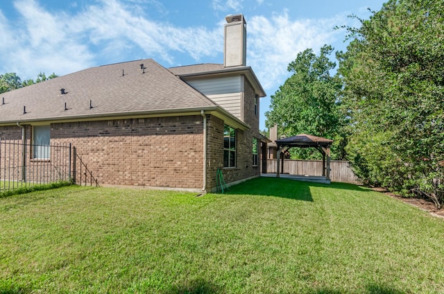 back of property with a gazebo and a lawn