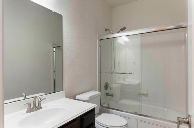 full bathroom featuring vanity, bath / shower combo with glass door, and toilet