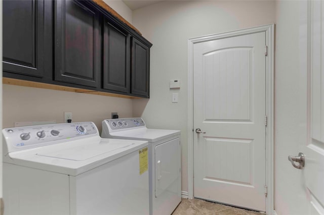 laundry room featuring cabinets, separate washer and dryer, and light tile patterned floors