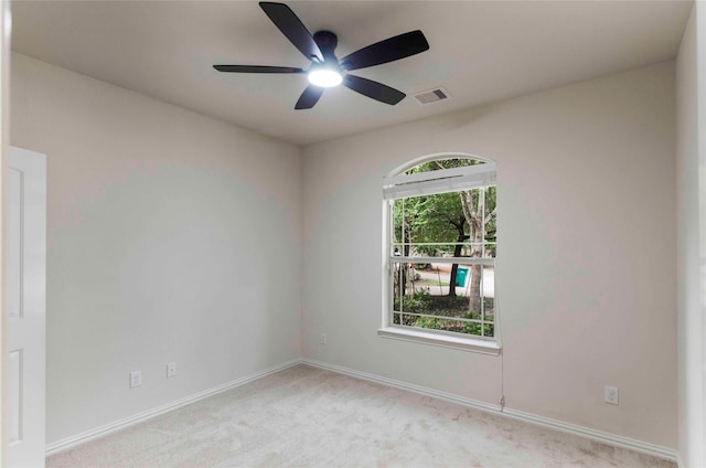 empty room featuring ceiling fan and light colored carpet