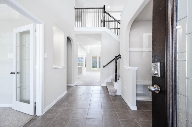 tiled foyer featuring french doors and a towering ceiling