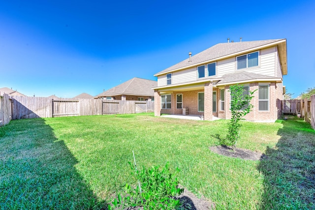 rear view of house featuring a patio area and a yard