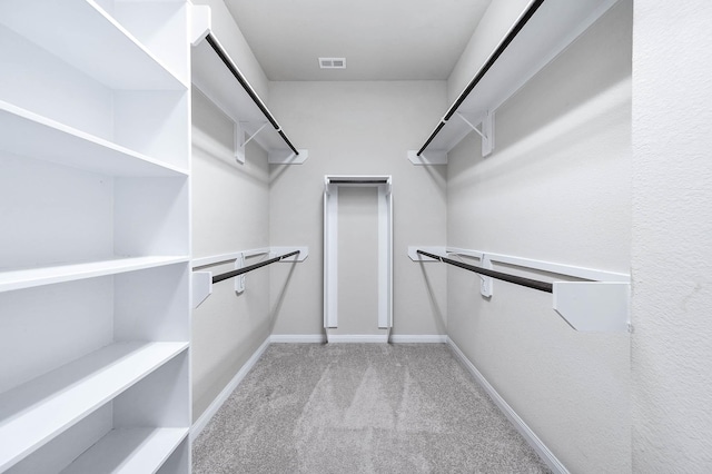 walk in closet featuring light colored carpet