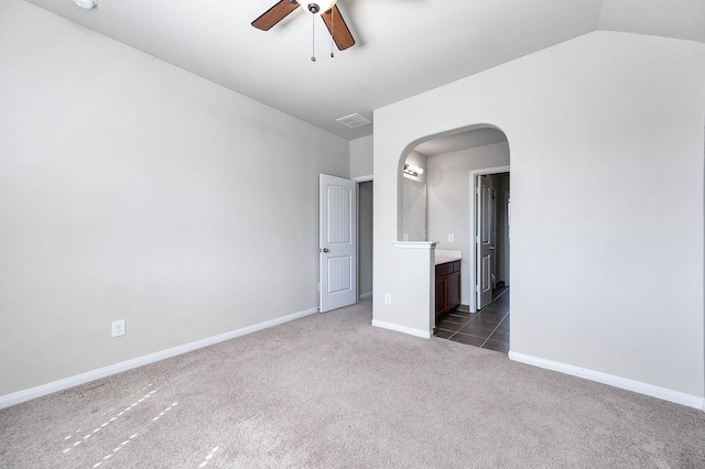 carpeted spare room with ceiling fan and vaulted ceiling