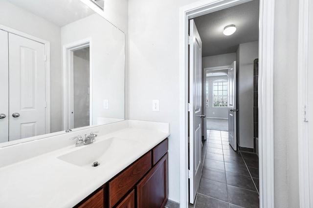 bathroom featuring tile patterned floors, vanity, and a textured ceiling