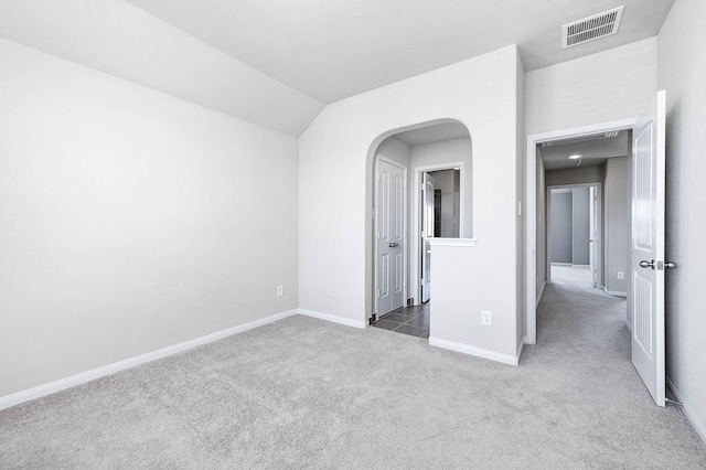 empty room featuring carpet flooring and vaulted ceiling