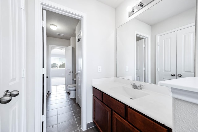 bathroom with tile patterned flooring, vanity, and toilet