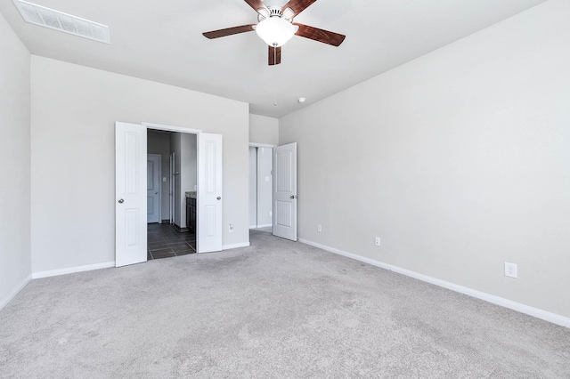 unfurnished bedroom with ceiling fan and dark carpet