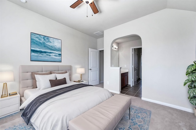 bedroom featuring connected bathroom, ceiling fan, vaulted ceiling, and dark colored carpet