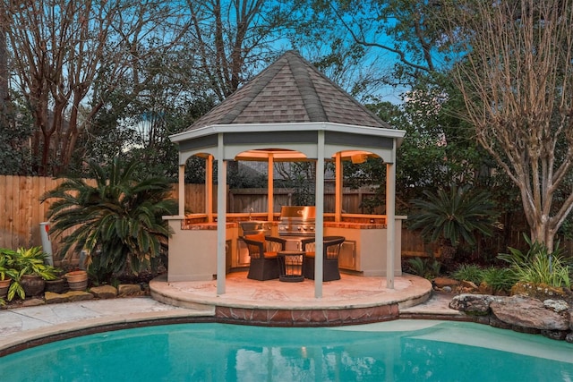 view of pool with a bar, area for grilling, and a gazebo