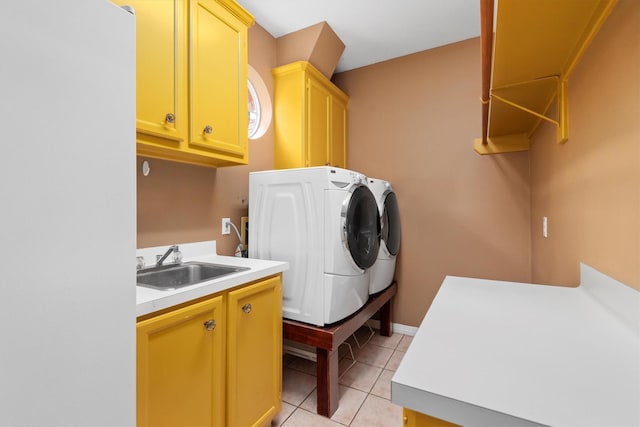 laundry room featuring cabinets, light tile patterned floors, washer and dryer, and sink