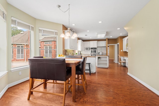 dining area featuring hardwood / wood-style floors and a chandelier