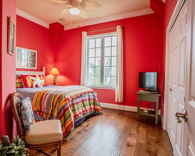 bedroom with ceiling fan, hardwood / wood-style flooring, a closet, and ornamental molding