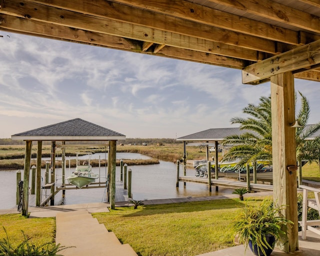 dock area with a water view and a yard