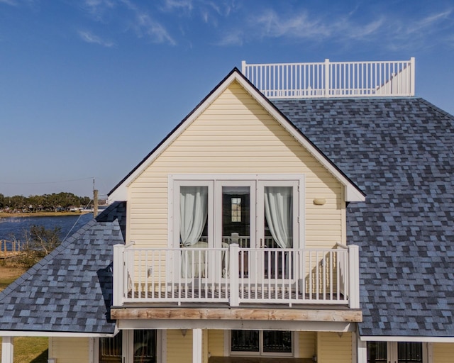 rear view of house with a balcony and a water view