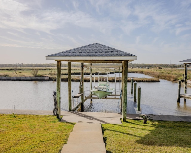 view of dock with a yard and a water view