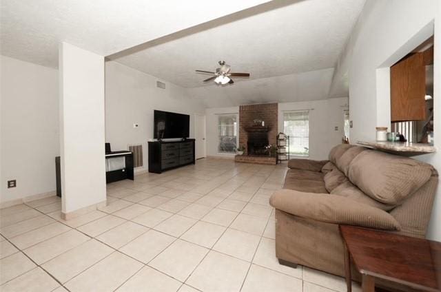 living room with ceiling fan, light tile patterned floors, vaulted ceiling, and a brick fireplace