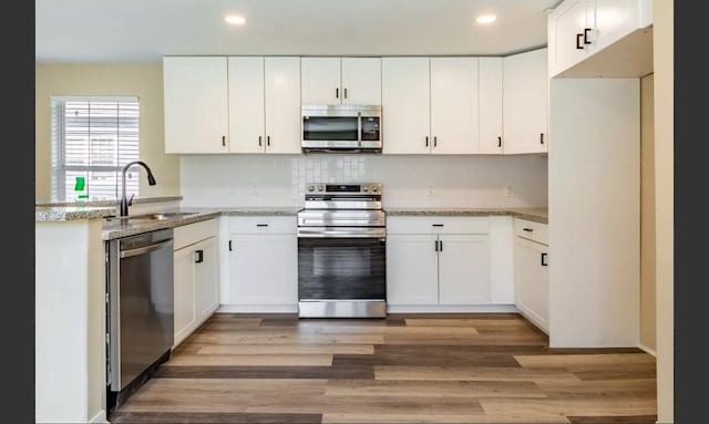 kitchen featuring stainless steel appliances, white cabinetry, and sink