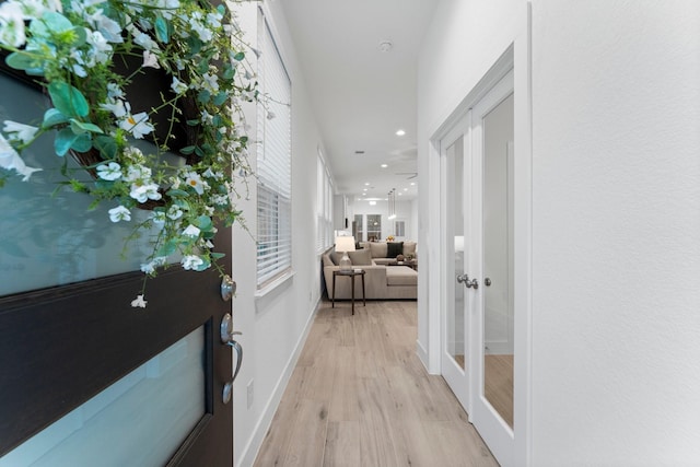 hallway featuring light hardwood / wood-style flooring and french doors