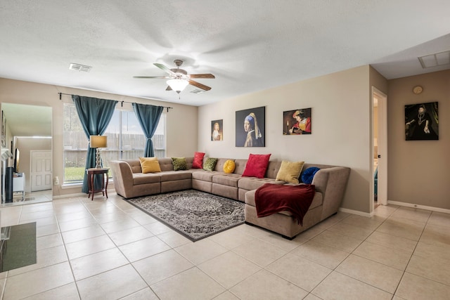 tiled living room with ceiling fan and a textured ceiling