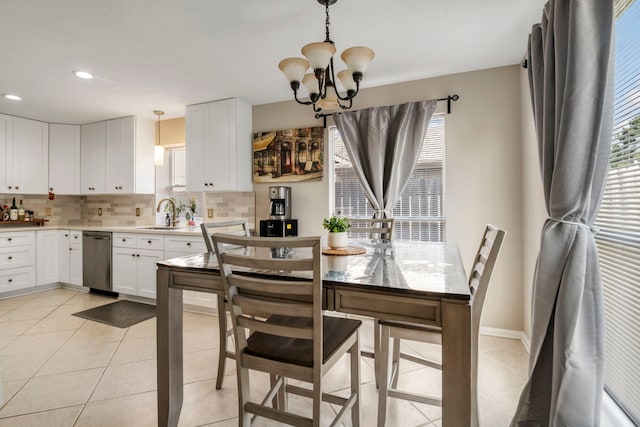 tiled dining room featuring a notable chandelier, plenty of natural light, and sink