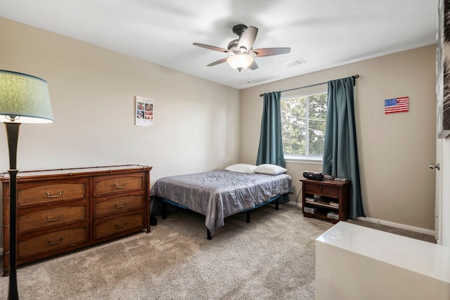 bedroom with ceiling fan and light carpet