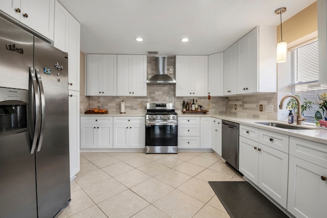 kitchen with white cabinets, sink, stainless steel appliances, and wall chimney range hood