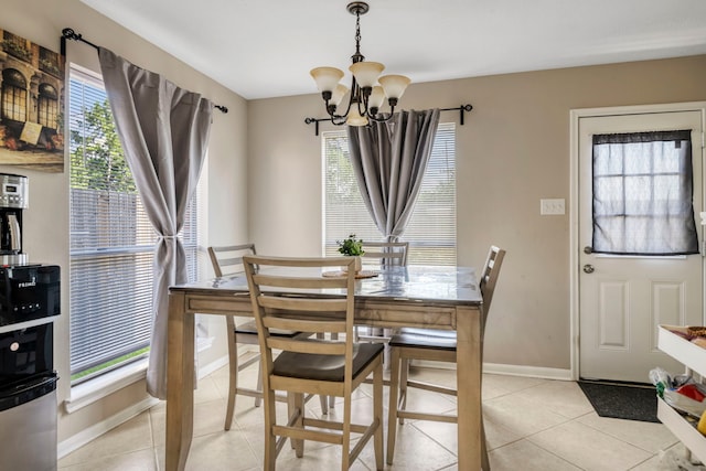 dining room with light tile patterned flooring, a wealth of natural light, and an inviting chandelier