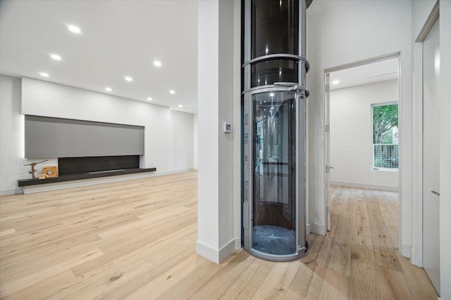 interior space featuring elevator and light hardwood / wood-style floors