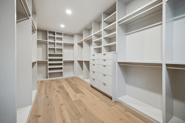 walk in closet with light hardwood / wood-style flooring