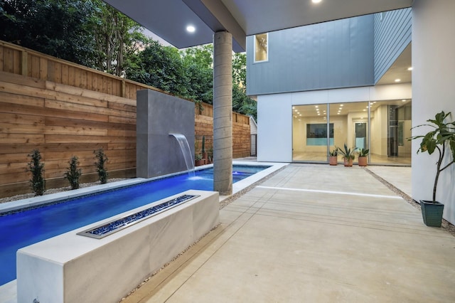 view of patio / terrace with pool water feature and a fire pit