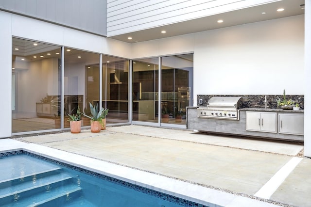 exterior space with an outdoor kitchen and a grill