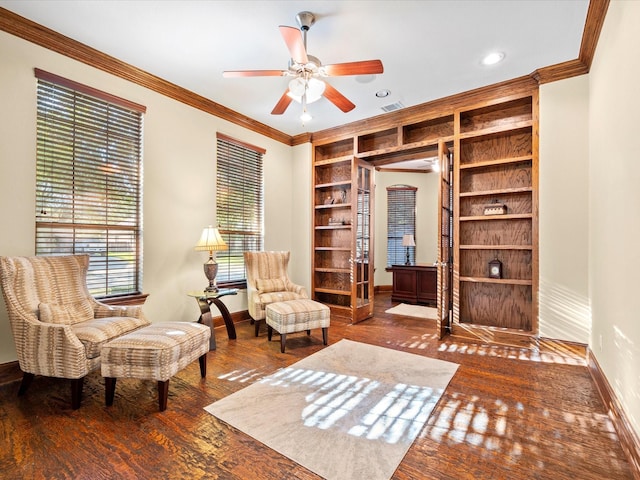 living area with ornamental molding, ceiling fan, built in features, and dark hardwood / wood-style floors