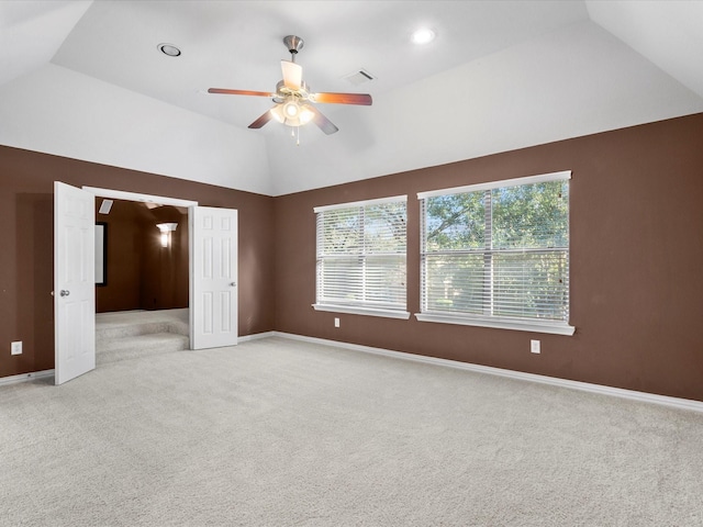 interior space with ceiling fan, vaulted ceiling, and a raised ceiling