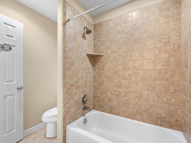 bathroom featuring tile patterned floors, tiled shower / bath combo, and toilet