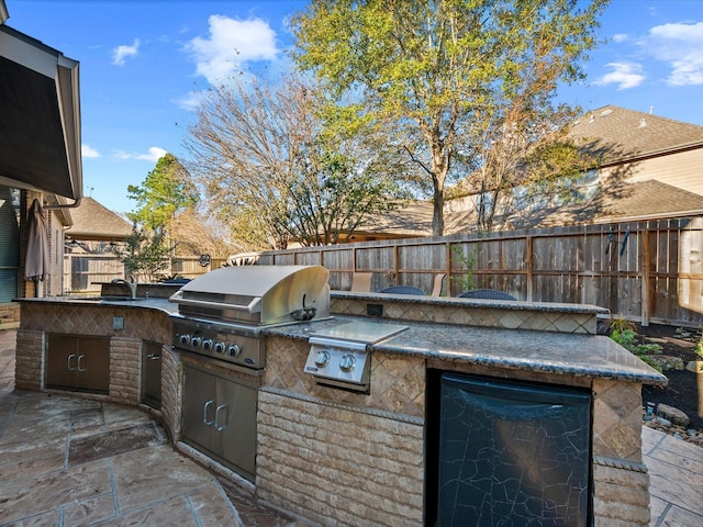 view of patio with an outdoor kitchen, grilling area, and sink