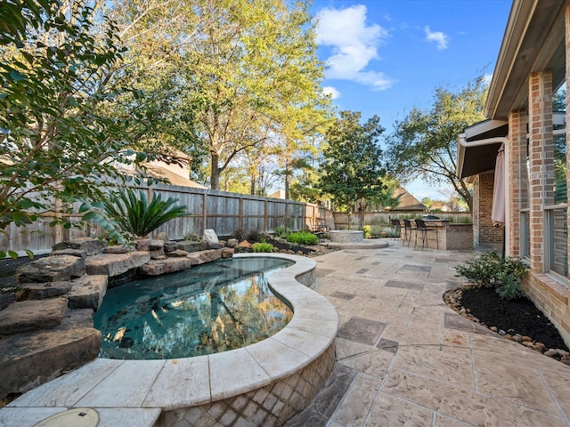 view of pool with an outdoor bar and a patio