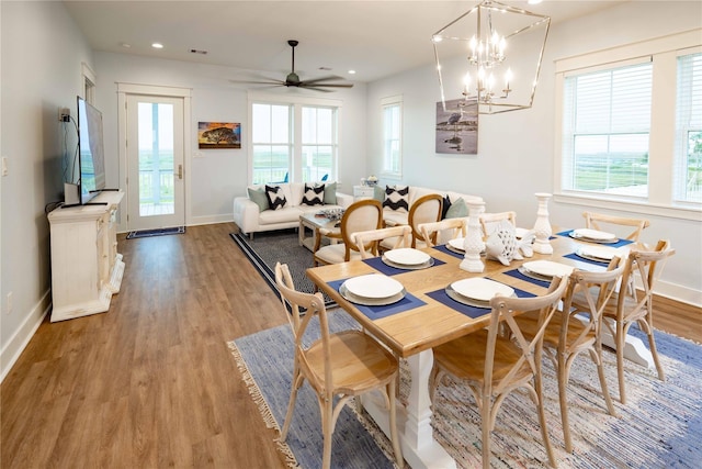 dining space featuring ceiling fan with notable chandelier, light hardwood / wood-style flooring, and a wealth of natural light