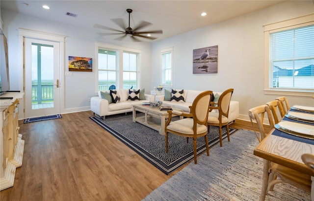 living room with ceiling fan and dark wood-type flooring