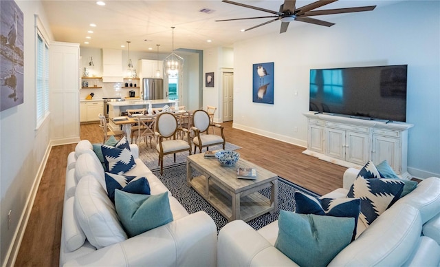 living room featuring hardwood / wood-style flooring and ceiling fan with notable chandelier