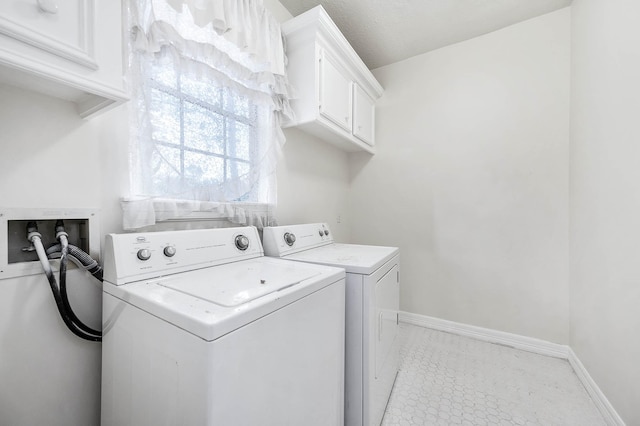 clothes washing area with cabinets and washer and dryer