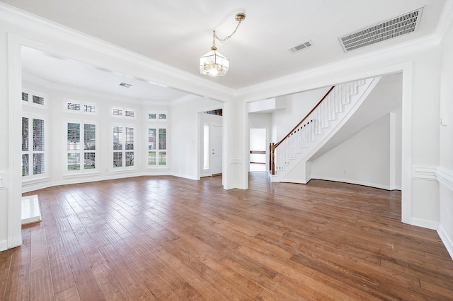 unfurnished living room featuring an inviting chandelier, dark hardwood / wood-style floors, and ornamental molding